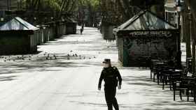 Un guardia urbano controla la reclusión en las Ramblas durante la Semana Santa