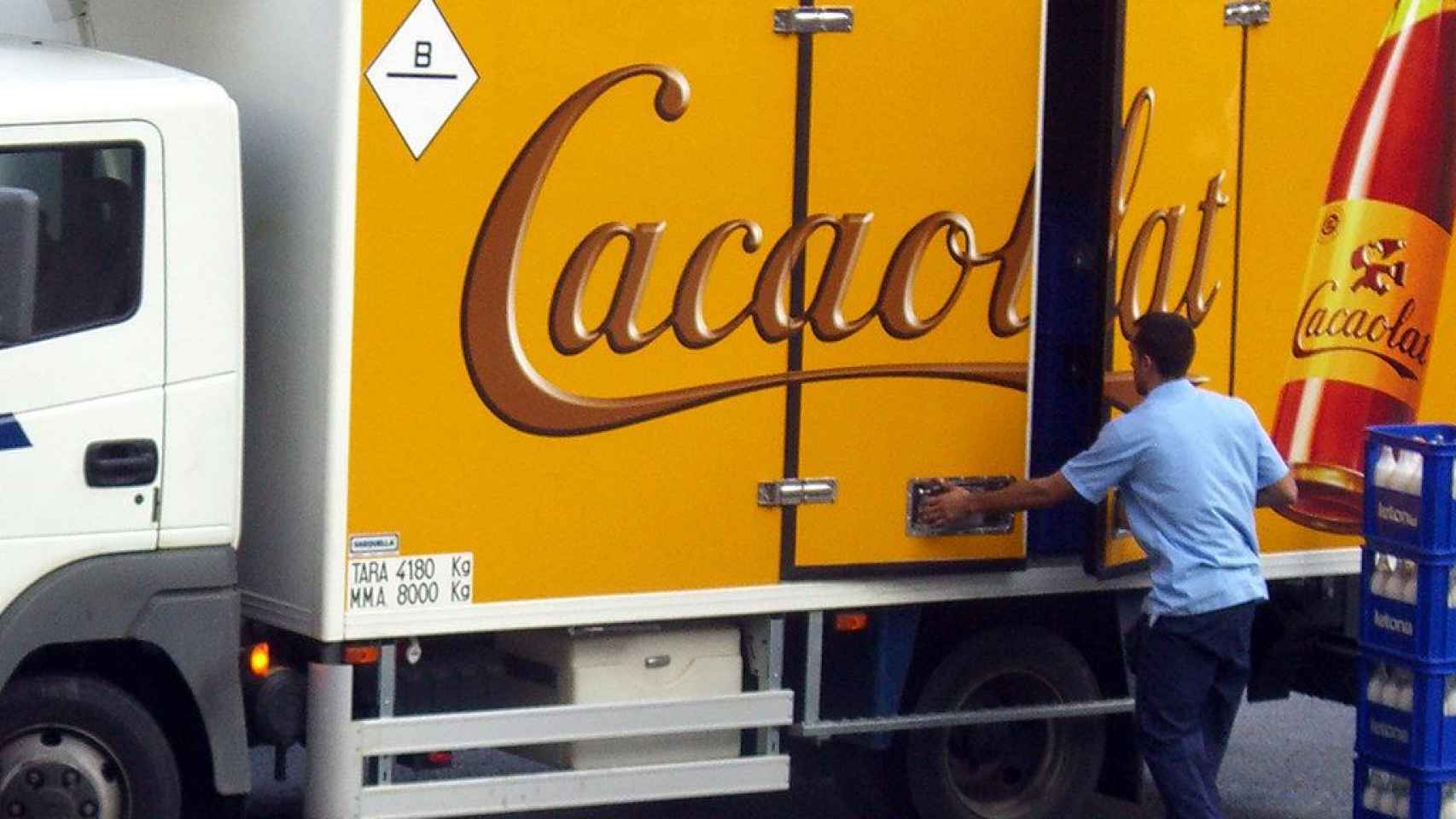 Un repartidor de la empresa Cacaolat junto a un camión