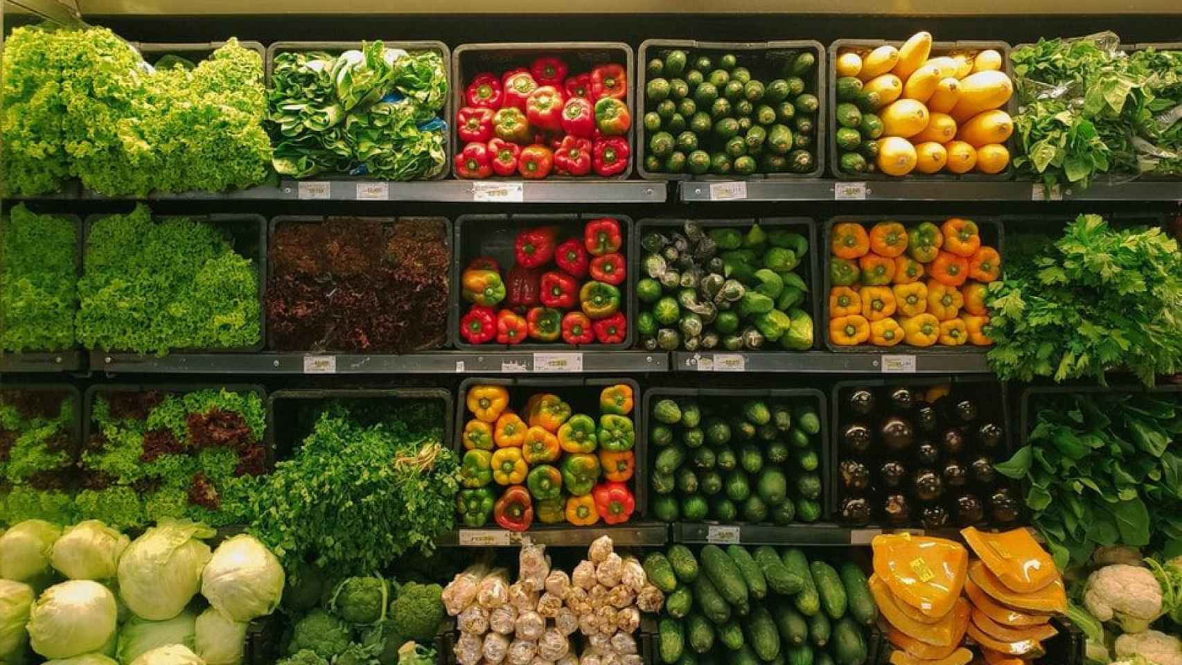 Varias estanterías de un supermercado llenas de verduras
