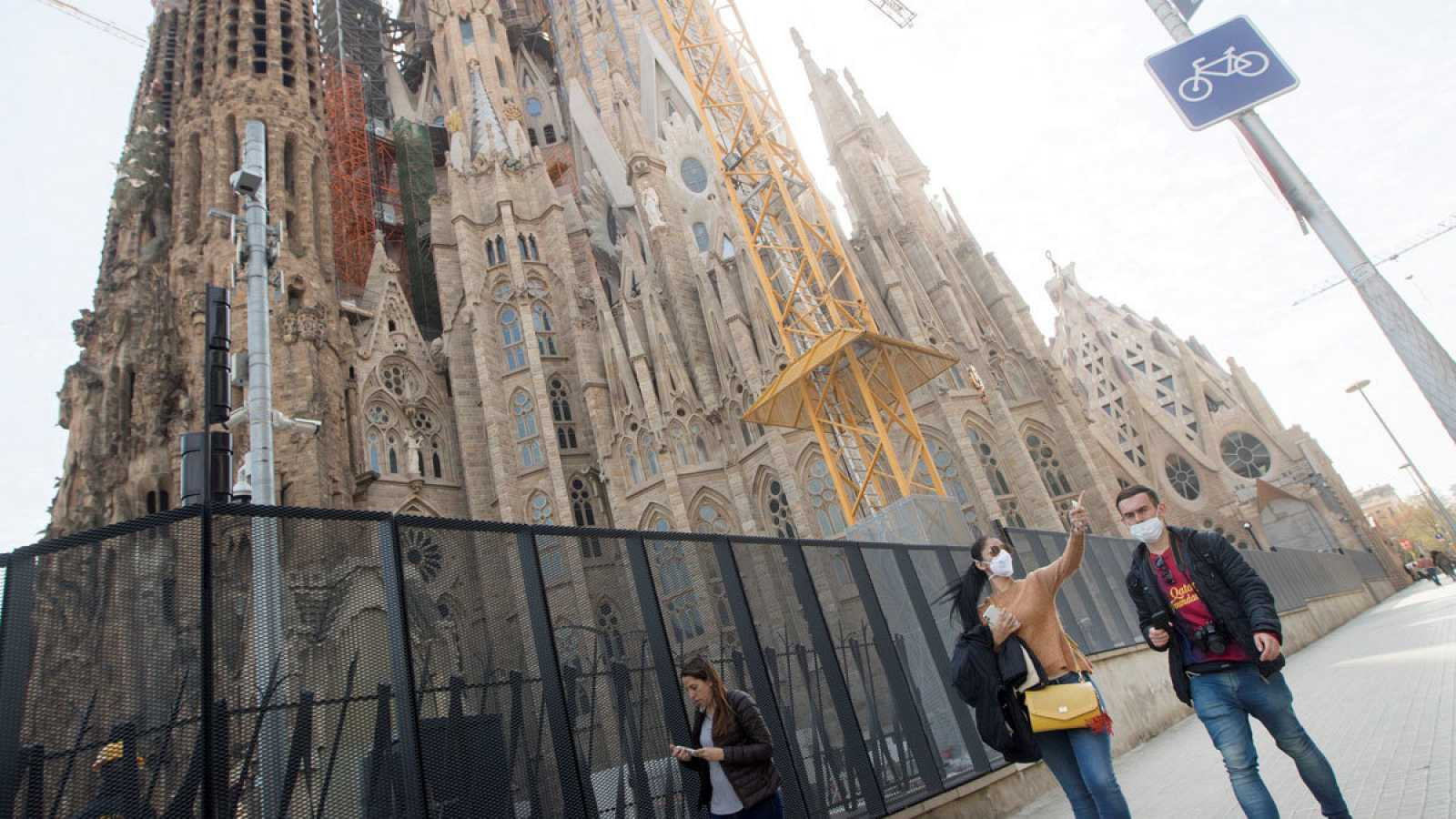 Dos personas con mascarillas junto a la Sagrada Família, en Barcelona / EFE MARTA PÉREZ