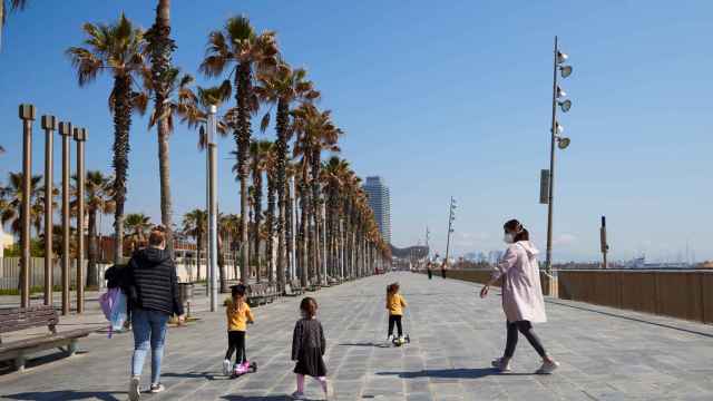 Dos mujeres con tres niños junto a las playas de Barcelona / EFE