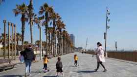 Dos mujeres con tres niños junto a las playas de Barcelona / EFE