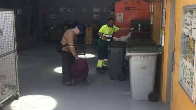 Un anciano con un trabajador en el punto verde de reciclaje de la Sagrada Família / JORDI SUBIRANA