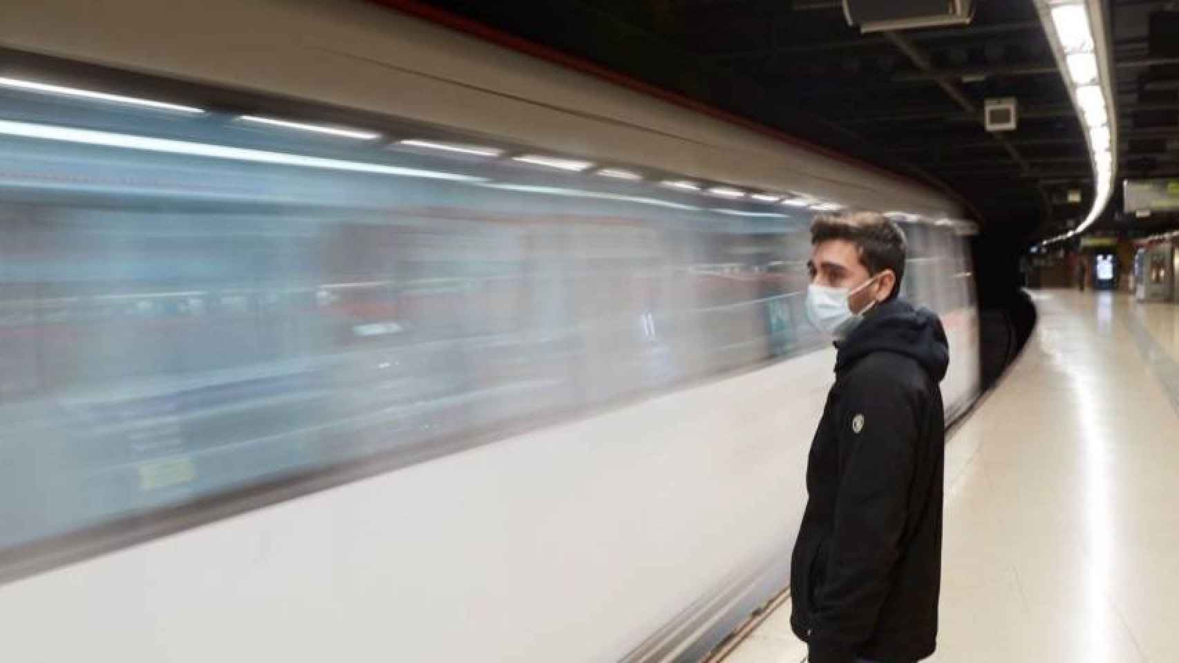 Un joven con mascarilla en el metro de Barcelona