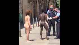 La pareja desnuda, junto a los Mossos, en una calle de Barcelona