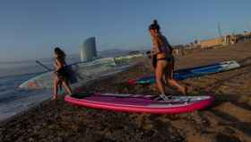 Varias personas se preparan para hacer paddle surf en la playa del Bogatell de Barcelona / EFE - ENRIC FONTCUBIERTA