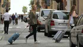 Dos jóvenes se dirigen a pisos turísticos en Barcelona / EFE