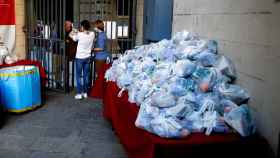 Decenas de bolsas de comida preparadas para ser repartidas entre los más vulnerables / EFE