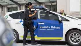 Dos agentes de la Guardia Urbana, junto a un coche patrulla / TWITTER GUARDIA URBANA