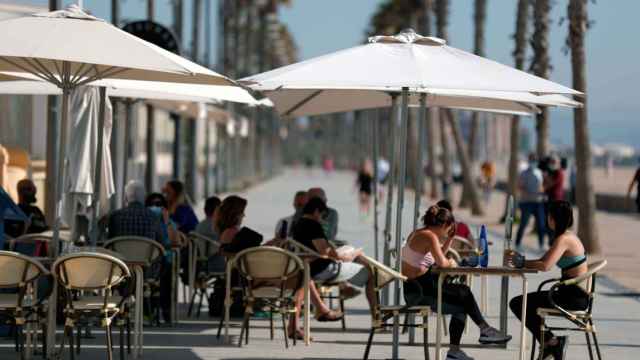 Una decena de personas en una terraza de la playa