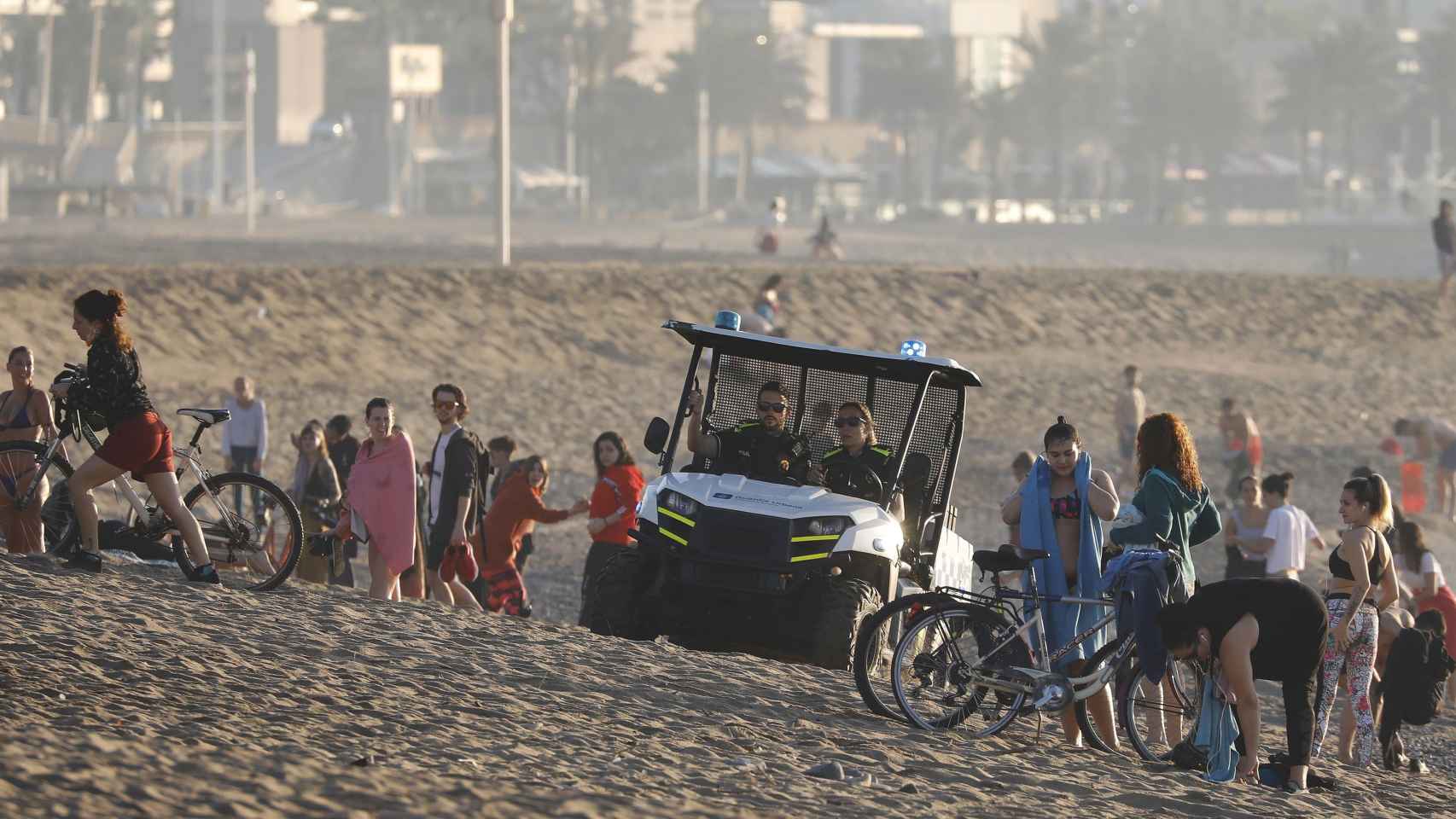 Agentes de la Guardia Urbana, en una playa de Barcelona, con numerosos usuarios / EFE ANDREU DALMAU