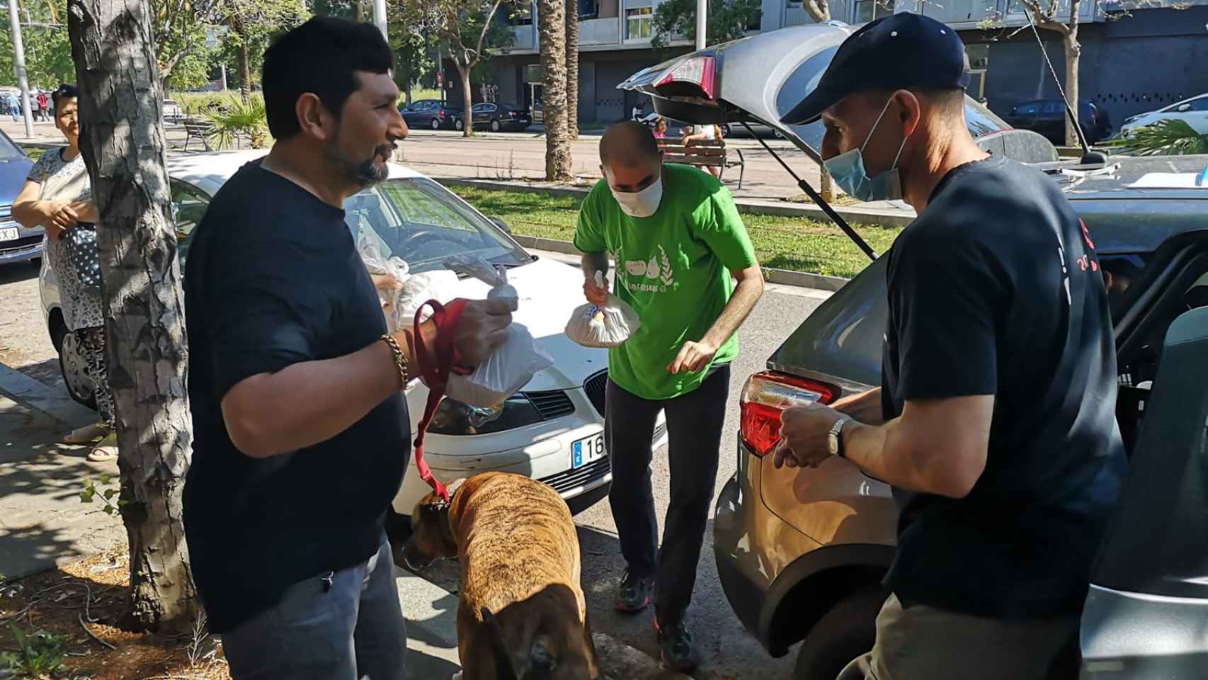 Agustí Clua (derecha) entrega una bolsa de comida a un vecino de La Mina / G.A