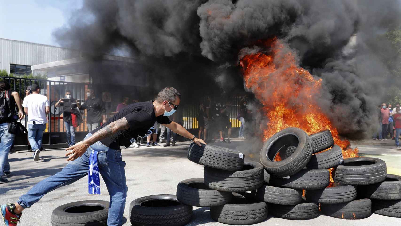 Un trabajador de Nissan quemando neumáticos