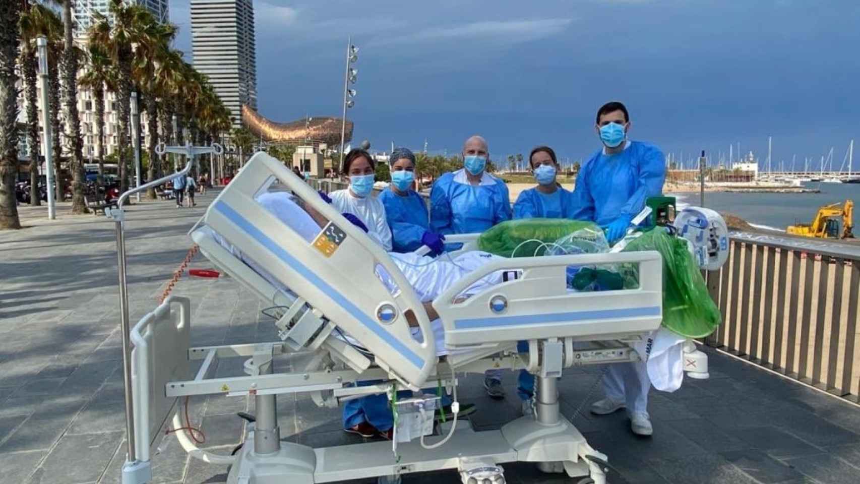 Sanitarios del Hospital del Mar con el paciente recuperado en el paseo marítimo / HOSPITAL DEL MAR