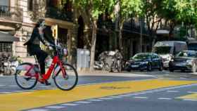 Una usuaria del Bicing con mascarilla en una calle de Barcelona / AYUNTAMIENTO DE BARCELONA
