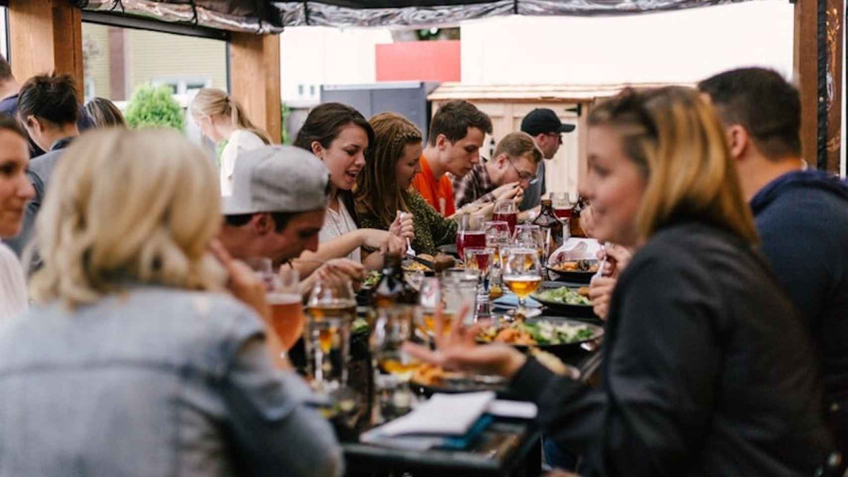 Una mesa llena de gente compartiendo diferentes platos