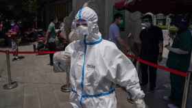 Un médico con un traje de protección en las inmediaciones del hospital de Youan, donde la gente se realiza el test de coronavirus en Pekín /EFE