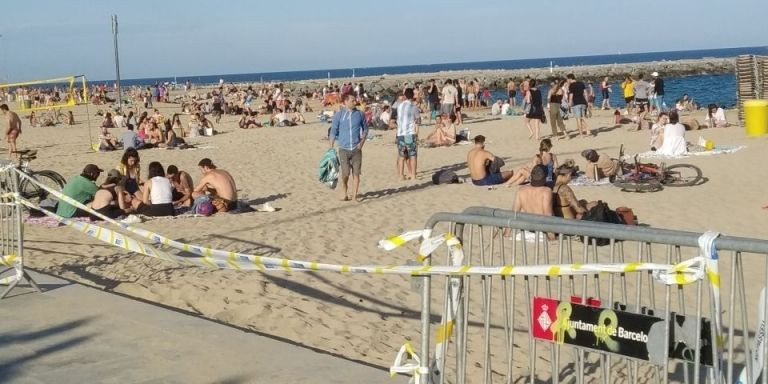 Vallas en una playa de Barcelona, llena de gente / JORDI SUBIRANA