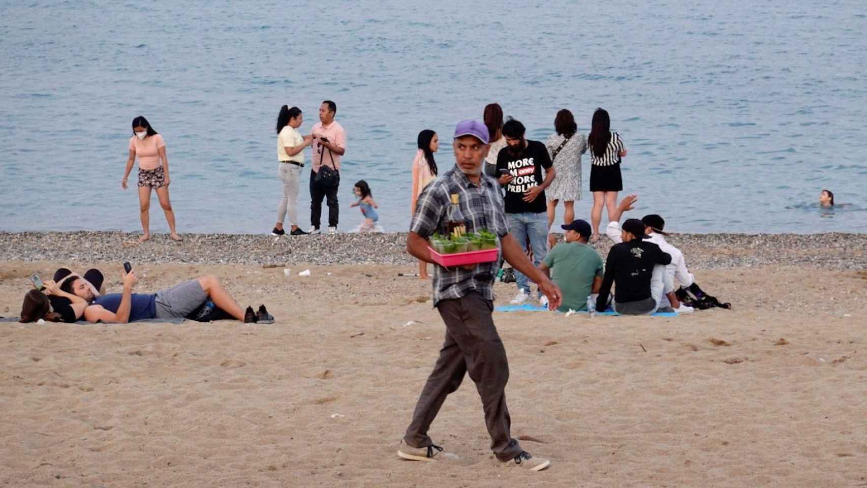 Un vendedor de bebidas pasea esta tarde en busca de clientes por la playa de La Barceloneta / EFE - ALEJANDRO GARCÍA