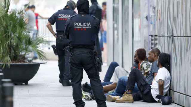 Mossos junto a un grupo de detenidos en el Raval / EFE