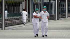 Dos profesionales sanitarios fuera de un recinto montado durante la pandemia / EFE