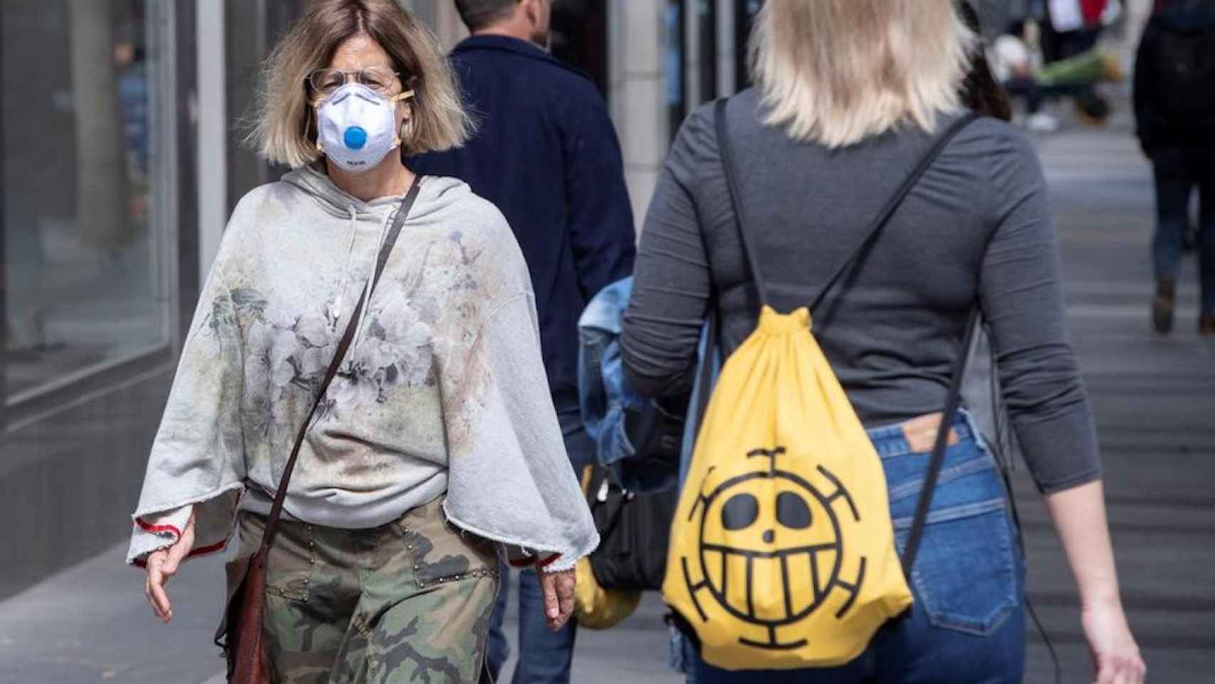El Govern impone más restricciones en tres municipios barceloneses. En la imagen, una mujer con la cara cubierta con una mascarilla / EFE