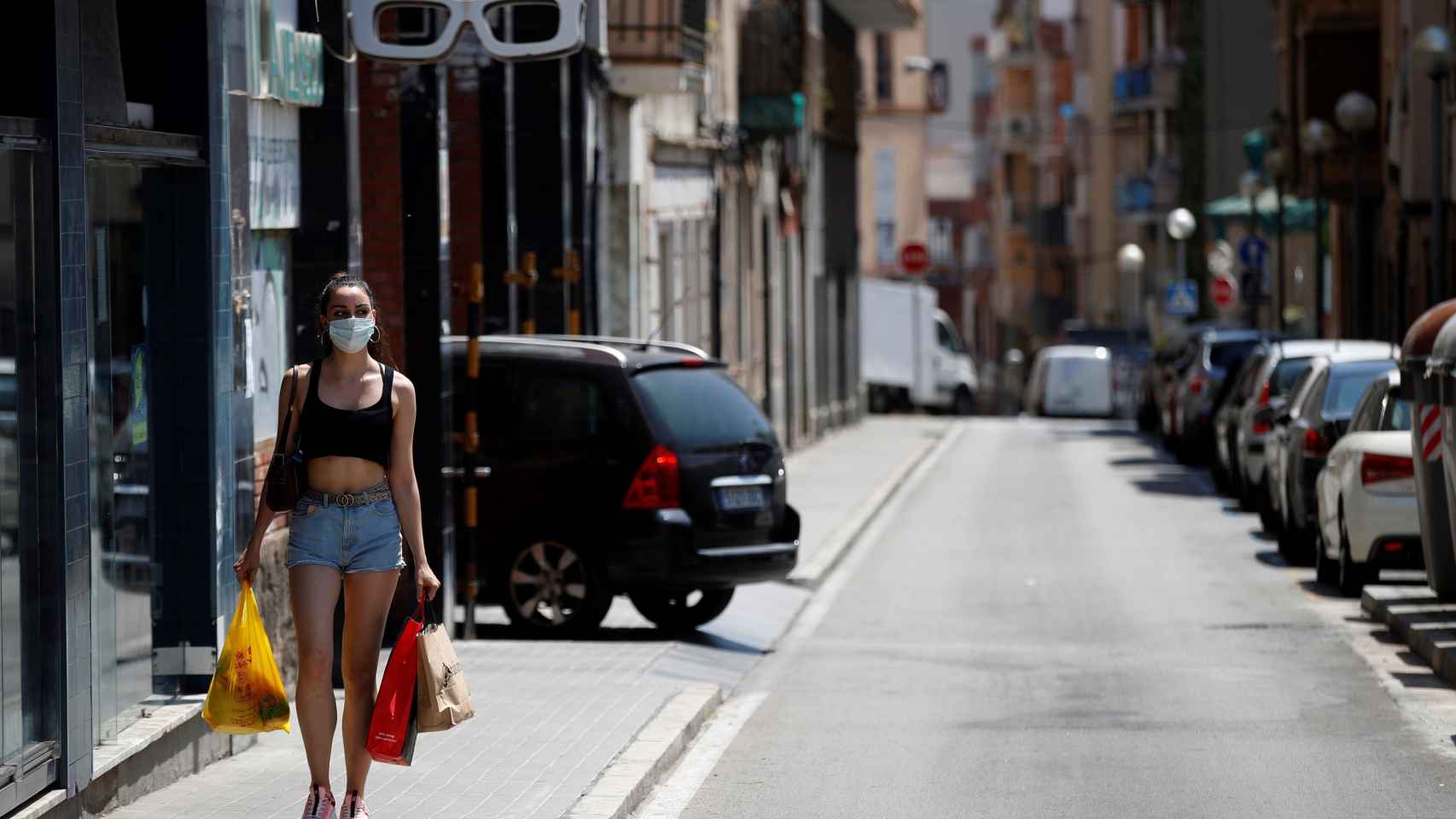 Una mujer paseando por el barrio de La Torrassa de L'Hospitalet, donde se han cifrado varios rebrotes de coronavirus / EFE - Toni Albir