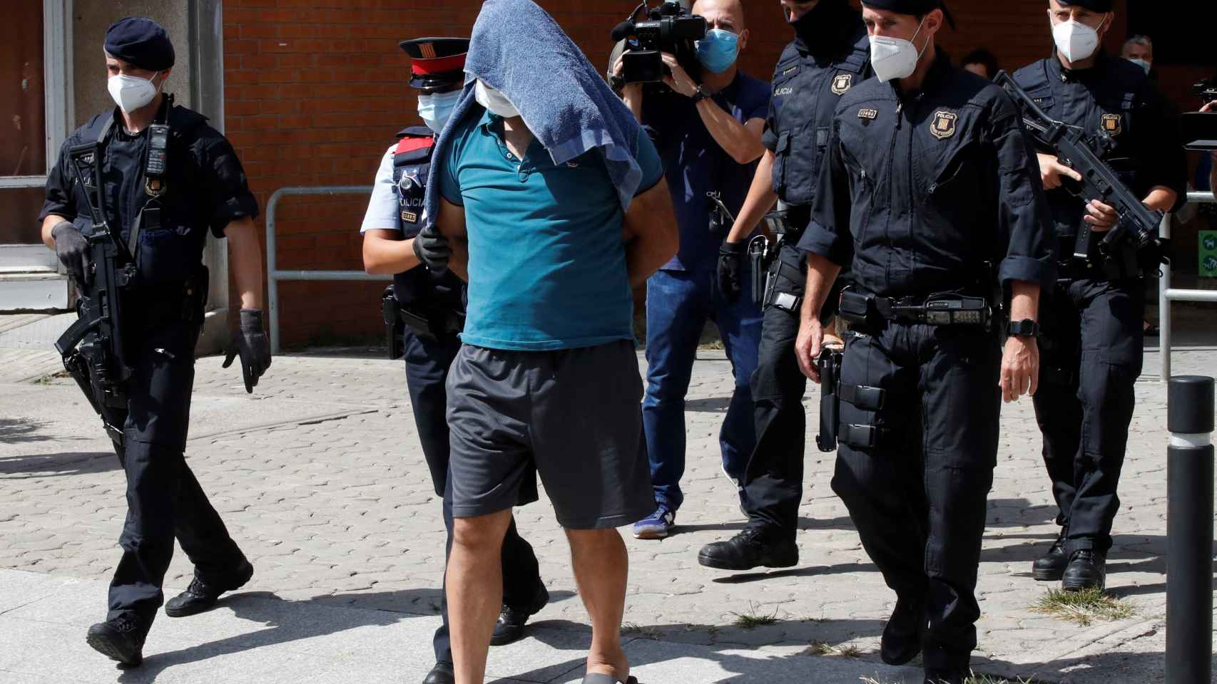 Mossos d'esquadra custodian a uno de los detenidos en la operación contra el terrorismo yihadista en el distrito de Ciutat Vella de Barcelona / EFE / Toni Albir