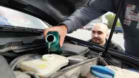 Un mecánico pone aceite de motor en un coche / ARCHIVO