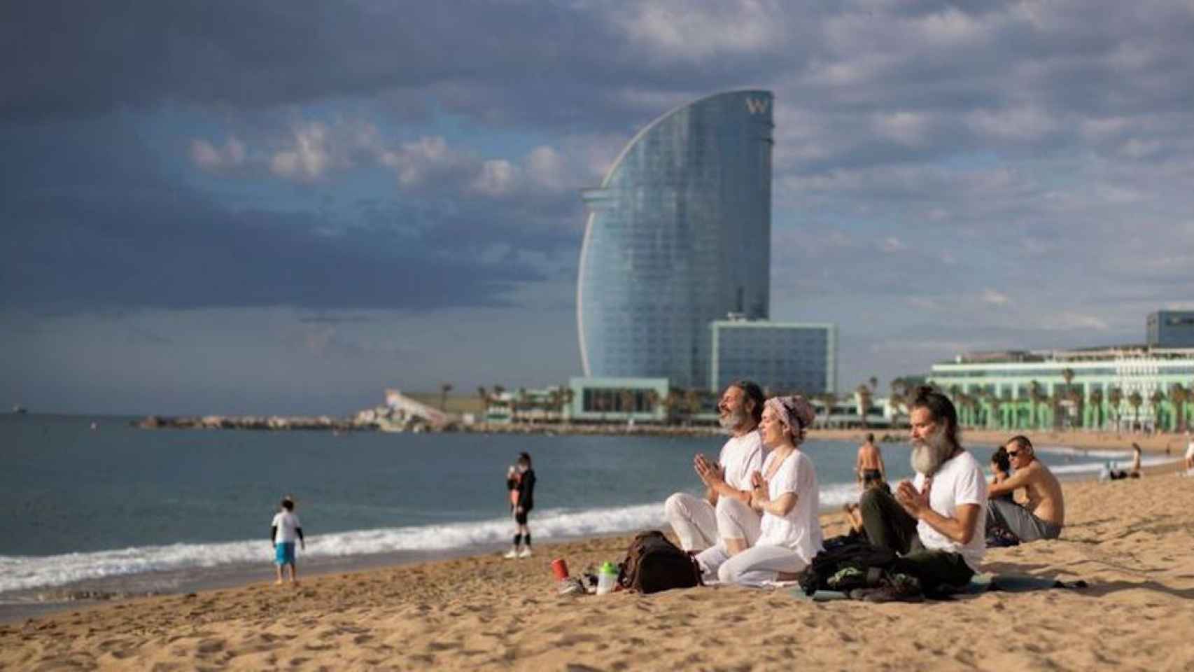 Fotografía del pasado 13 de junio, donde unas personas meditan en la playa de la Barceloneta / EFE - MARTA PÉREZ