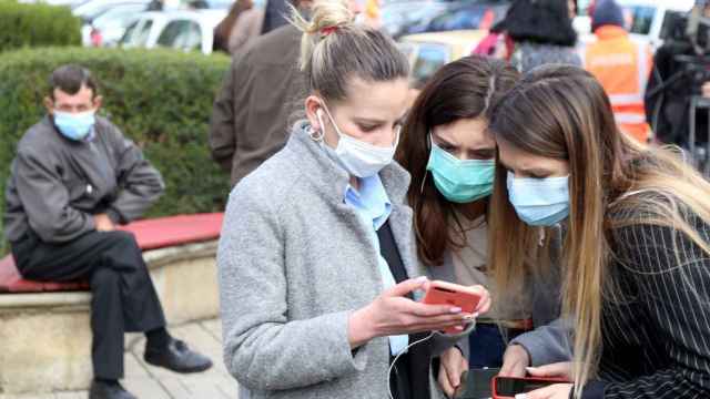 Imagen de archivo de tres jóvenes protegiéndose con mascarillas por el coronavirus / EFE