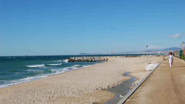 Playa de Premià de Mar, con una persona andando por el paseo marítimo