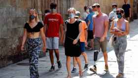 Un grupo de turistas en Barcelona, con mascarilla, durante el pasado verano / EFE - TONI ALBIR