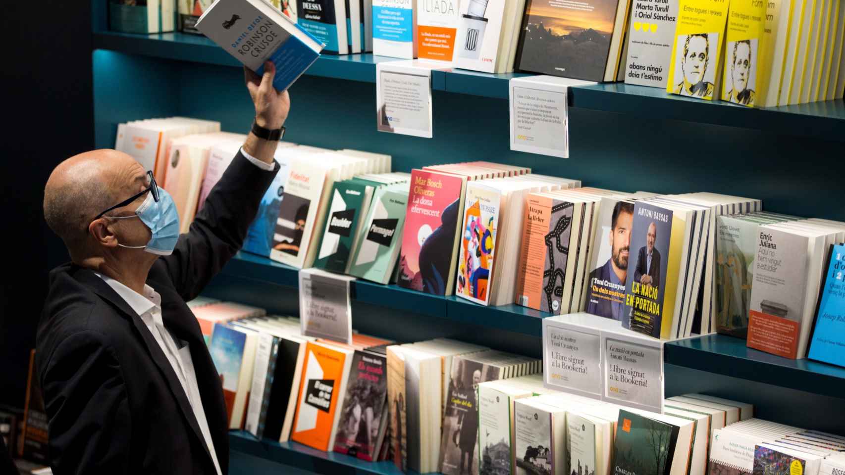 Un hombre sujeta un libro en una librería de Barcelona este jueves / EFE