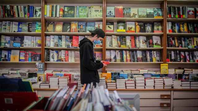 Un joven observa un libro de la papelería Demos, en Barcelona / EUROPA PRESS - David Zorrakino