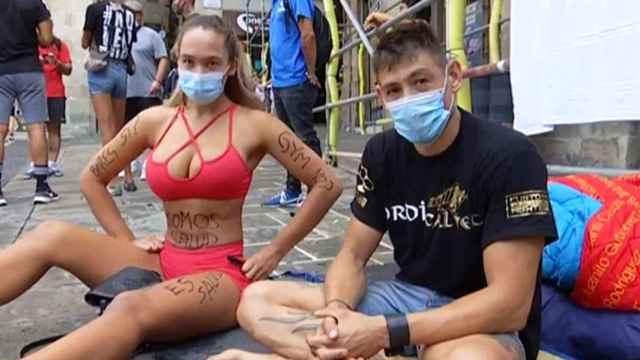 Dos personas sentadas en Plaza Sant Jaume reivindicando la reapertura de los gimnasios