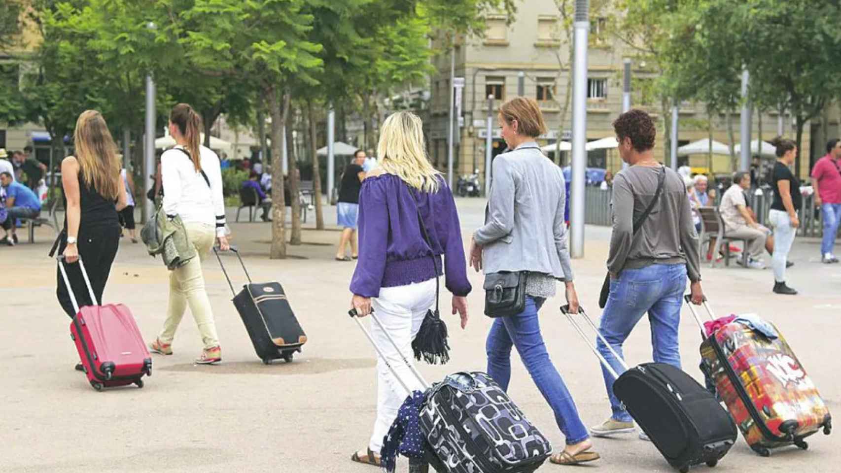 Varios turistas cargados con maletas en Barcelona