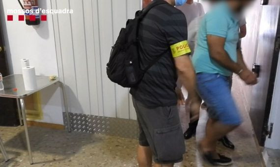 Los mossos inspeccionan el trastero en presencia del detenido / MOSSOS
