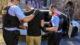 Un presunto ladrón es conducido hasta un coche policial por dos mossos / MOSSOS D'ESQUADRA