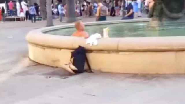 Captura de pantalla del vídeo en el que se ve como un hombre se tuesta al sol y se zambulle en la fuente de la plaza Reial / BMAGAZINE