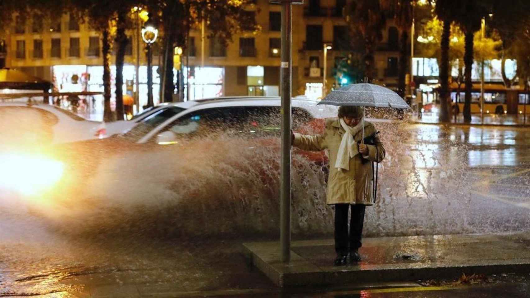 Una mujer sufriendo las consecuencias de la lluvia en Barcelona / EFE