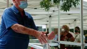 Un hombre se pone gel para evitar el contagio de la Covid, en Sant Boi (Barcelona) / EFE - QUIQUE GARCÍA