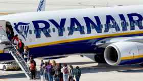 Dos decenas de pasajeros esperando para subir al vuelo de un avión de Ryanair / EFE