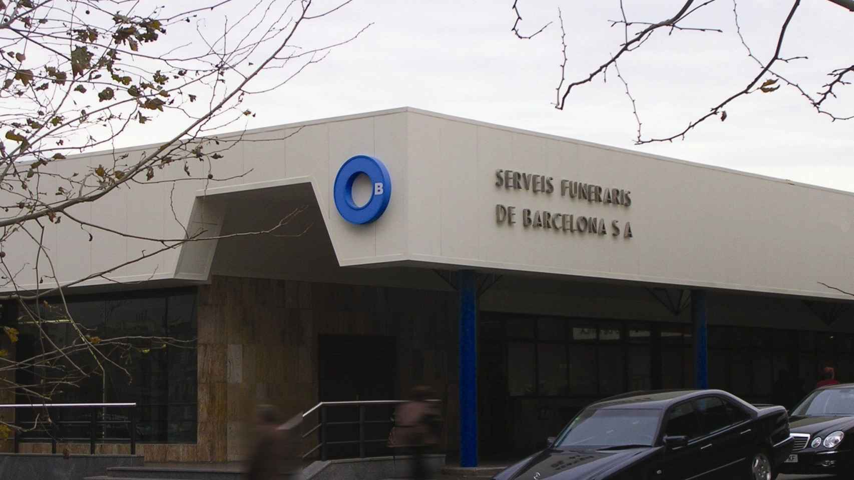 Exterior del edificio de Serveis Funeraris de Barcelona, con un coche fúnebre aparcado