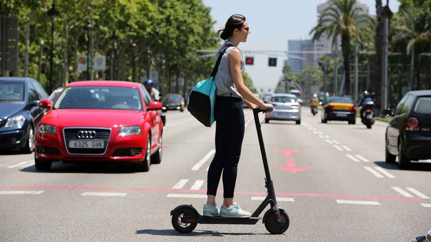 Una mujer con un patinete eléctrico en la avenida Diagonal de Barcelona