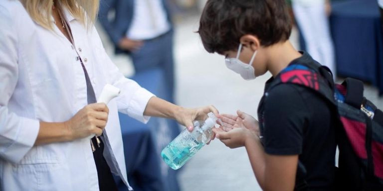 Un niño se desinfecta las manos en la entrada de la American School of Barcelona, en Esplugues / EFE- MARTA PÉREZ