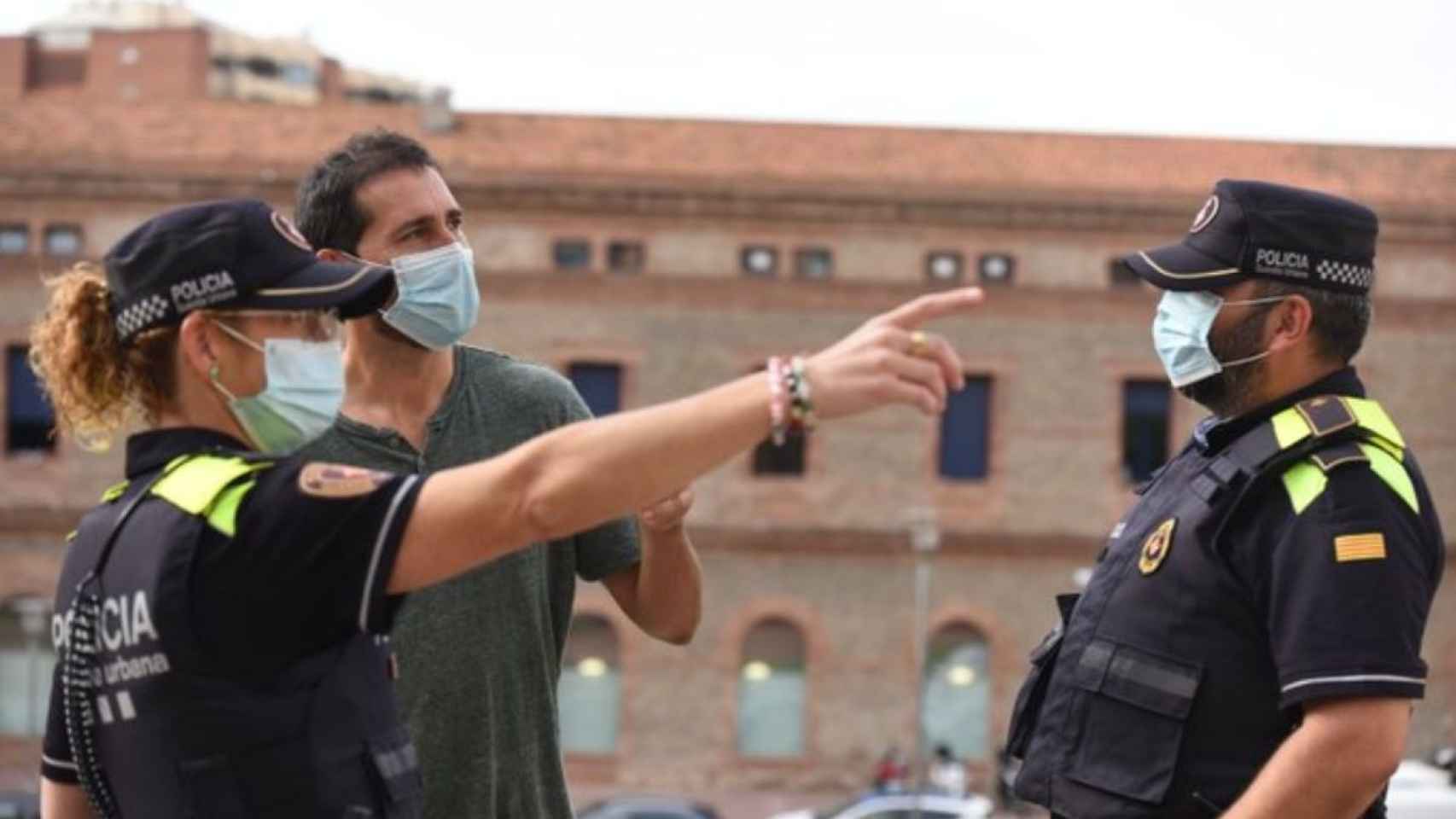 Una agente de la Guardia Urbana de Barcelona hace indicaciones a un hombre / GUARDIA URBANA