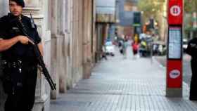 Imagen de un agente de los Mossos d'Esquadra con una arma larga vigilando Las Ramblas de Barcelona / EFE