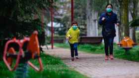 Un niño protegido con una mascarilla corre por un parque / EFE