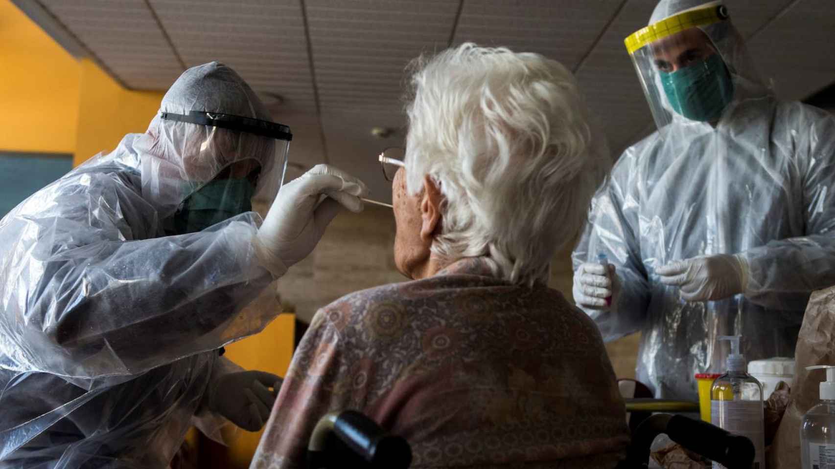 Trabajadores de una residencia realizan un test a una anciana / EFE